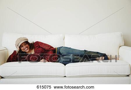 Woman lays on sofa View Large Photo Image Stock Photography - Woman lays on sofa. Fotosearch