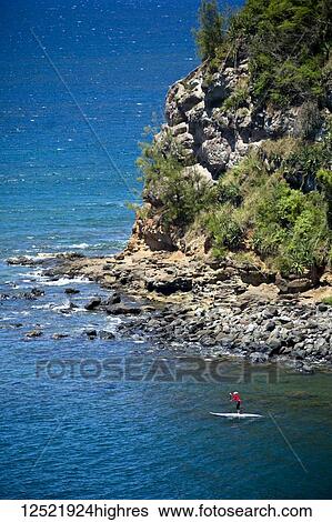 Woman paddling out from Maliko Gulch on stand up paddle board, near Paia; Maui, Hawaii, United States of America View Large Photo Image Stock Photograph - Woman paddling out from Maliko Gulch on stand up paddle board, near Paia; Maui, Hawaii, United States of America. Fotosearch