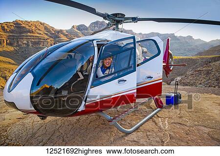 Stock Photograph - Woman posing in a landed helicopter on a Grand Canyon scenery tour; Las Vegas, Nevada, United States of America. Fotosearch