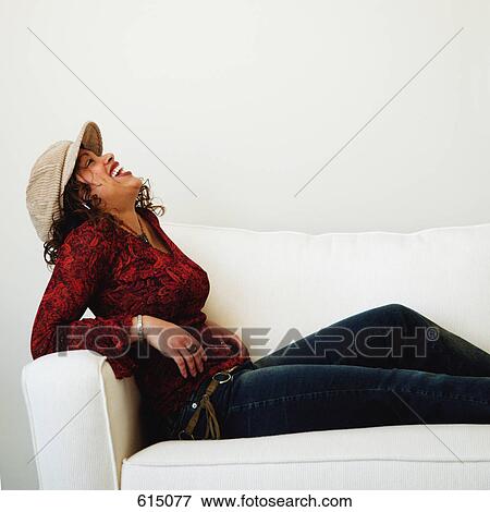 Stock Photo - Woman relaxes on sofa. Fotosearch