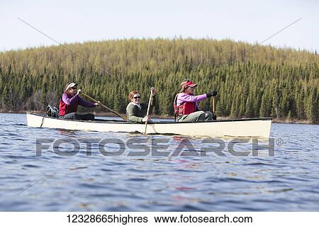 Stock Photograph - Women canoeing in the Swanson Lake area, Kenai Peninsula, South-central Alaska; Alaska, United States of America. Fotosearch