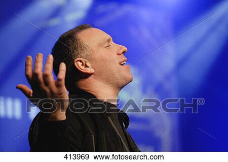Stock Photo - Worship leader raising hands. Fotosearch
