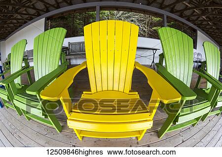 Yellow and green adirondack chairs on a wooden covered deck, Gardens of Hope respite cabin; New Glasgow, Prince Edward Island, Canada View Large Photo Image Stock Photograph - Yellow and green adirondack chairs on a wooden covered deck, Gardens of Hope respite cabin; New Glasgow, Prince Edward Island, Canada. Fotosearch