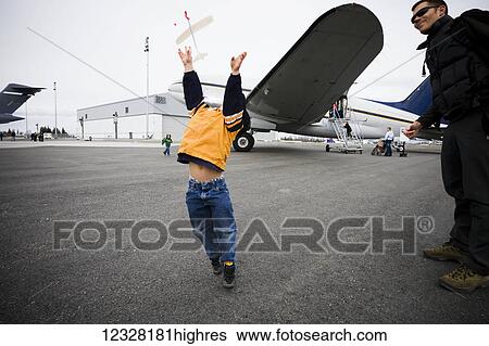 Stock Photograph - Young Boy Playing With A Toy Airplane At The Alaska Airmen's Air Show, Alaska, USA. Fotosearch