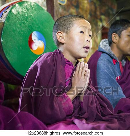 Stock Photograph - Young buddhist monk in a pose of worship; Sikkim, India. Fotosearch