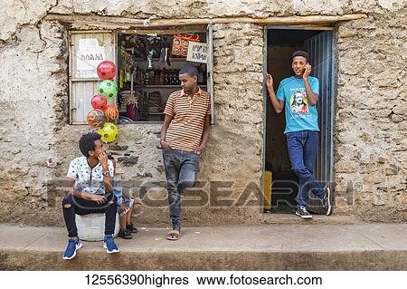 Stock Photograph - Young Ethiopian men outside a shop; Gondar, Amhara Region, Ethiopia. Fotosearch