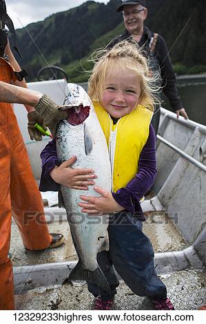 Young girl holding a salmon in a set-net skiff, South-central Alaska; Seldovia, Alaska, United States of America View Large Photo Image Stock Photograph - Young girl holding a salmon in a set-net skiff, South-central Alaska; Seldovia, Alaska, United States of America. Fotosearch