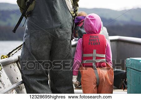 Stock Photograph - Young girl in her family's set-net skiff, Seldovia, South-central Alaska; Alaska, United States of America. Fotosearch