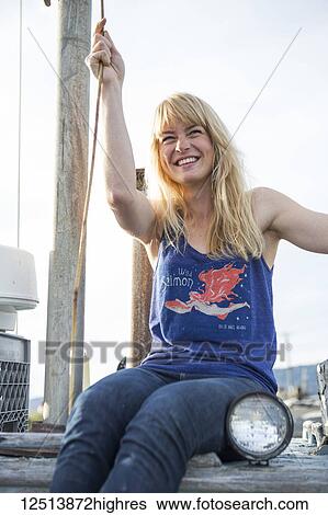 Stock Photograph - Young woman hanging out on abandoned equipment along coastal Homer, South-central Alaska; Homer, Alaska, United States of America. Fotosearch