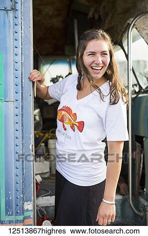 Stock Photograph - Young woman on vintage equipment along coastal Homer, South-central Alaska; Homer, Alaska, United States of America. Fotosearch