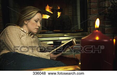 Young woman reading book in front of fireplace View Large Photo Image Stock Photo - Young woman reading book in front of fireplace. Fotosearch