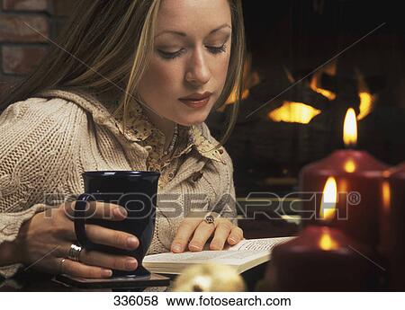 Young woman reading book in front of fireplace View Large Photo Image Stock Photo - Young woman reading book in front of fireplace. Fotosearch