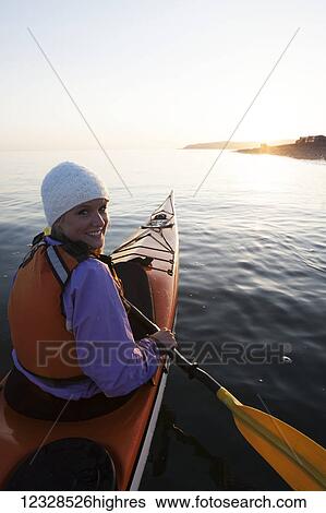 Stock Photograph - Young woman sea kayaking in Kachemak Bay, near Homer, South-central Alaska; Alaska, United States of America. Fotosearch