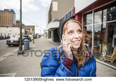 Young woman talking on her smartphone in downtown Anchorage, South-central Alaska; Anchorage, Alaska, United States of America View Large Photo Image Stock Photograph - Young woman talking on her smartphone in downtown Anchorage, South-central Alaska; Anchorage, Alaska, United States of America. Fotosearch