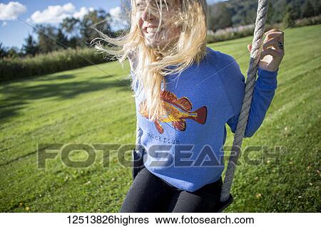 Young woman with long, blond hair on a swing, South-central Alaska; Homer, Alaska, United States of America View Large Photo Image Stock Photograph - Young woman with long, blond hair on a swing, South-central Alaska; Homer, Alaska, United States of America. Fotosearch