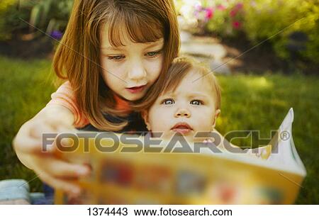 A child reading a book to a toddler View Large Photo Image Stock Image - A child reading a book to a toddler. Fotosearch
