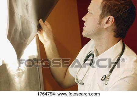 A doctor looks at an x-ray View Large Photo Image Picture - A doctor looks at an x-ray. Fotosearch