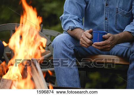 A man sits by the fire View Large Photo Image Picture - A man sits by the fire. Fotosearch