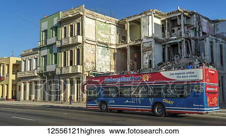 A tour bus passes the weathered facade of old buildings along a street; Havana, Cuba View Large Photo Image Stock Photograph - A tour bus passes the weathered facade of old buildings along a street; Havana, Cuba. Fotosearch