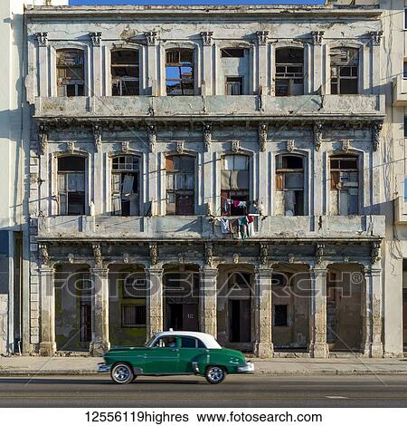 An old car passes the weathered facade of old buildings along a street; Havana, Cuba View Large Photo Image Stock Photograph - An old car passes the weathered facade of old buildings along a street; Havana, Cuba. Fotosearch