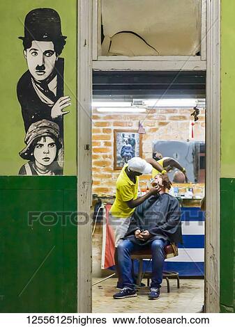 Barber shop with a man getting a shave and an image of Charlie Chaplin on the wall; Havana, Cuba View Large Photo Image Stock Photograph - Barber shop with a man getting a shave and an image of Charlie Chaplin on the wall; Havana, Cuba. Fotosearch