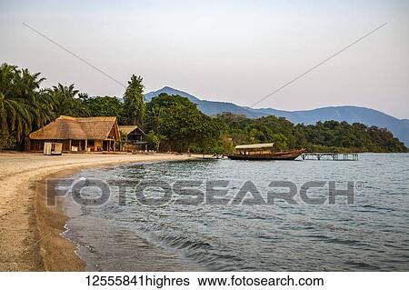 Boat moored to dock in front of Mbali Mballi Mahale Lodge (Kungwe Beach Lodge) in Mahale Mountains National Park on the shores of Lake Tanganyika, Tanzania View Large Photo Image Stock Photograph - Boat moored to dock in front of Mbali Mballi Mahale Lodge (Kungwe Beach Lodge) in Mahale Mountains National Park on the shores of Lake Tanganyika, Tanzania. Fotosearch