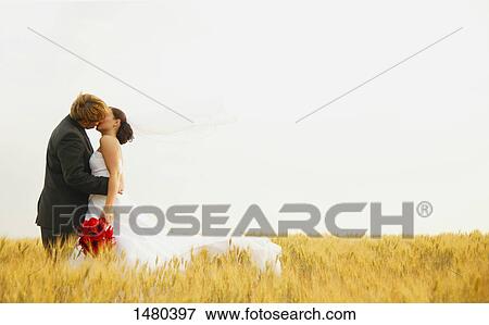 Stock Photo - Bride and groom kiss. Fotosearch