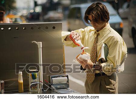 Businessman gets a hotdog View Large Photo Image Stock Photograph - Businessman gets a hotdog. Fotosearch