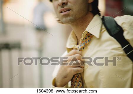 Stock Photo - Businessman holds tie. Fotosearch