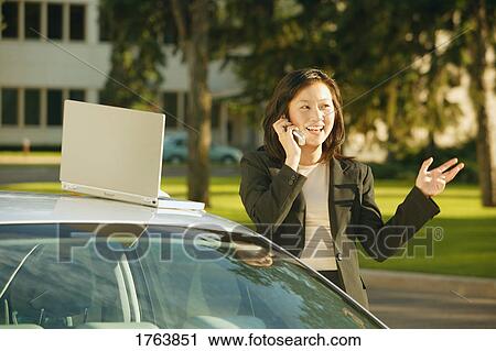 Stock Image - Businesswoman has conversation on cell phone. Fotosearch