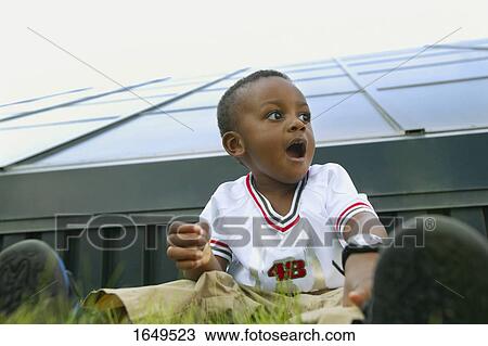 Stock Image - Child sitting on the grass. Fotosearch