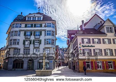 Stock Photograph - Colourful residential and retail buildings and pedestrians in a town square; St. Gallen, St. Gallen, Switzerland. Fotosearch