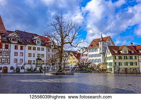 Stock Photograph - Colourful residential buildings and pedestrians in a town square; St. Gallen, St. Gallen, Switzerland. Fotosearch