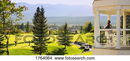 Couple enjoy the view of a golf resort View Large Photo Image Picture - Couple enjoy the view of a golf resort. Fotosearch