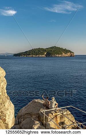Couple enjoying the sunset and the view of Lokrum Island; Dubrovnik, Dubrovnik-Neretva County, Croatia View Large Photo Image Stock Photograph - Couple enjoying the sunset and the view of Lokrum Island; Dubrovnik, Dubrovnik-Neretva County, Croatia. Fotosearch