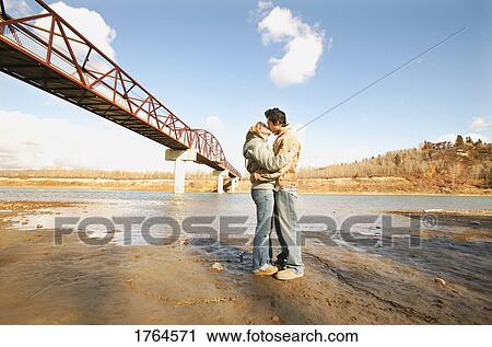 Stock Image - Couple kiss in river valley. Fotosearch