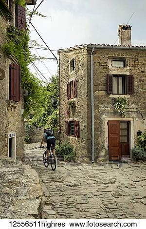 Cyclist on a cobblestone street in the picturesque medieval town given over to artists known as Groznjan; Groznjan, Istria, Croatia View Large Photo Image Stock Photograph - Cyclist on a cobblestone street in the picturesque medieval town given over to artists known as Groznjan; Groznjan, Istria, Croatia. Fotosearch