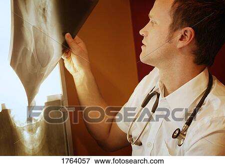 Doctor looks at x-ray View Large Photo Image Stock Photo - Doctor looks at x-ray. Fotosearch