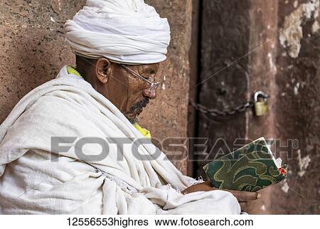 Ethiopian Orthodox priest reading the Bible at the Northern Group of the Rock-Hewn Churches; Lalibela, Amhara Region, Ethiopia View Large Photo Image Stock Photograph - Ethiopian Orthodox priest reading the Bible at the Northern Group of the Rock-Hewn Churches; Lalibela, Amhara Region, Ethiopia. Fotosearch
