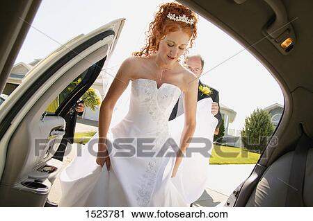 Stock Image - Getting into the wedding vehicle. Fotosearch