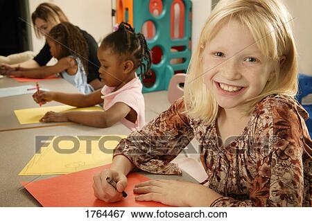 Stock Photo - Girl colors a picture. Fotosearch