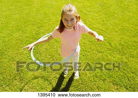 Girl playing with hoola hoop View Large Photo Image Stock Image - Girl playing with hoola hoop. Fotosearch