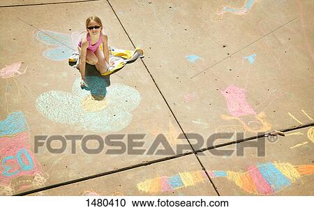 Stock Image - Girl plays with sidewalk chalk. Fotosearch