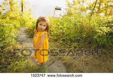 Girl stands on a path View Large Photo Image Stock Photo - Girl stands on a path. Fotosearch