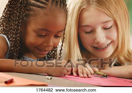 Stock Image - Girls color together. Fotosearch
