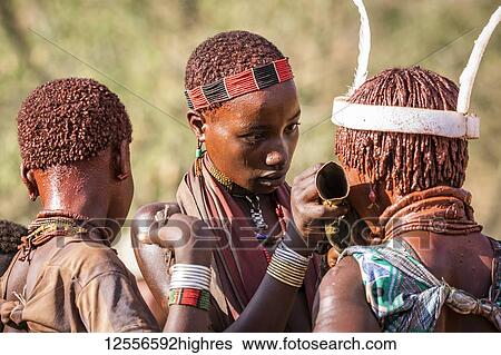 Stock Photograph - Hamer girls at a bull jumping ceremony, which initiates a boy into manhood, in the village of Asile; Omo Valley, Ethiopia. Fotosearch