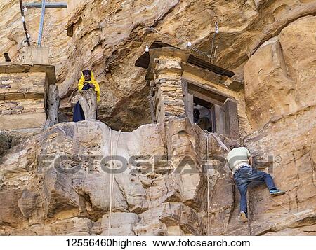Stock Photograph - Man climbing on a rope to reach Debre Damo monastery; Tigray Region, Ethiopia. Fotosearch