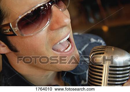 Stock Image - Man sings into microphone. Fotosearch