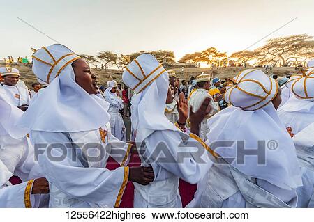 Stock Photograph - People in a Timkat procession during the Orthodox Tewahedo celebration of Epiphany, celebrated on January 19th; Bulbula, Oromia, Ethiopia. Fotosearch