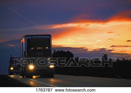 Semi truck driving at sunset/sunrise View Large Photo Image Stock Photo - Semi truck driving at sunset/sunrise. Fotosearch